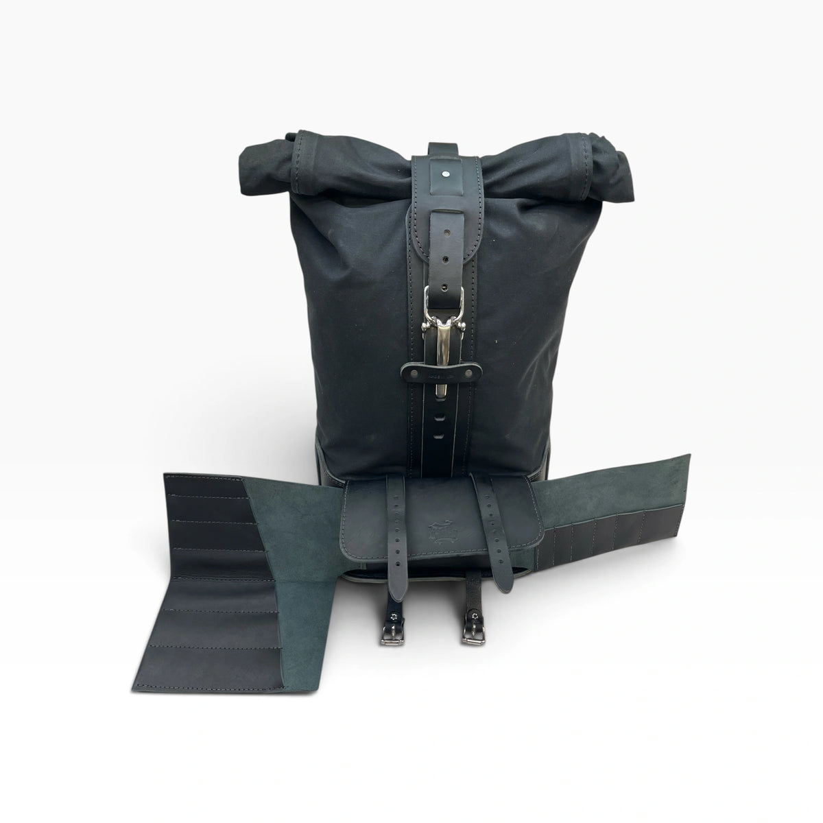 A black roll-top bicycle bag with attached rear rack straps and mounting hardware, photographed on a clean white background.
